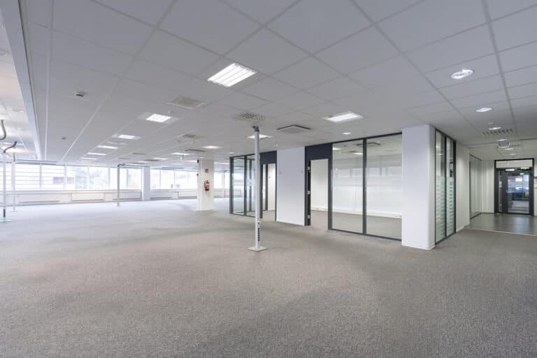 Ylimmän kerroksen avara toimistotila neuvotteluhuoneella.